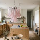 26 pink lattimo Mrano glass chandelier hangin in a kitchen