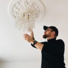 Jakob from cherry vintage hanging up a chandelier.